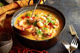 Moqueca Baiana - peixe cozido com leite de coco, azeite de dendê, pimentões e coentro, prato colorido servido em panela de barro